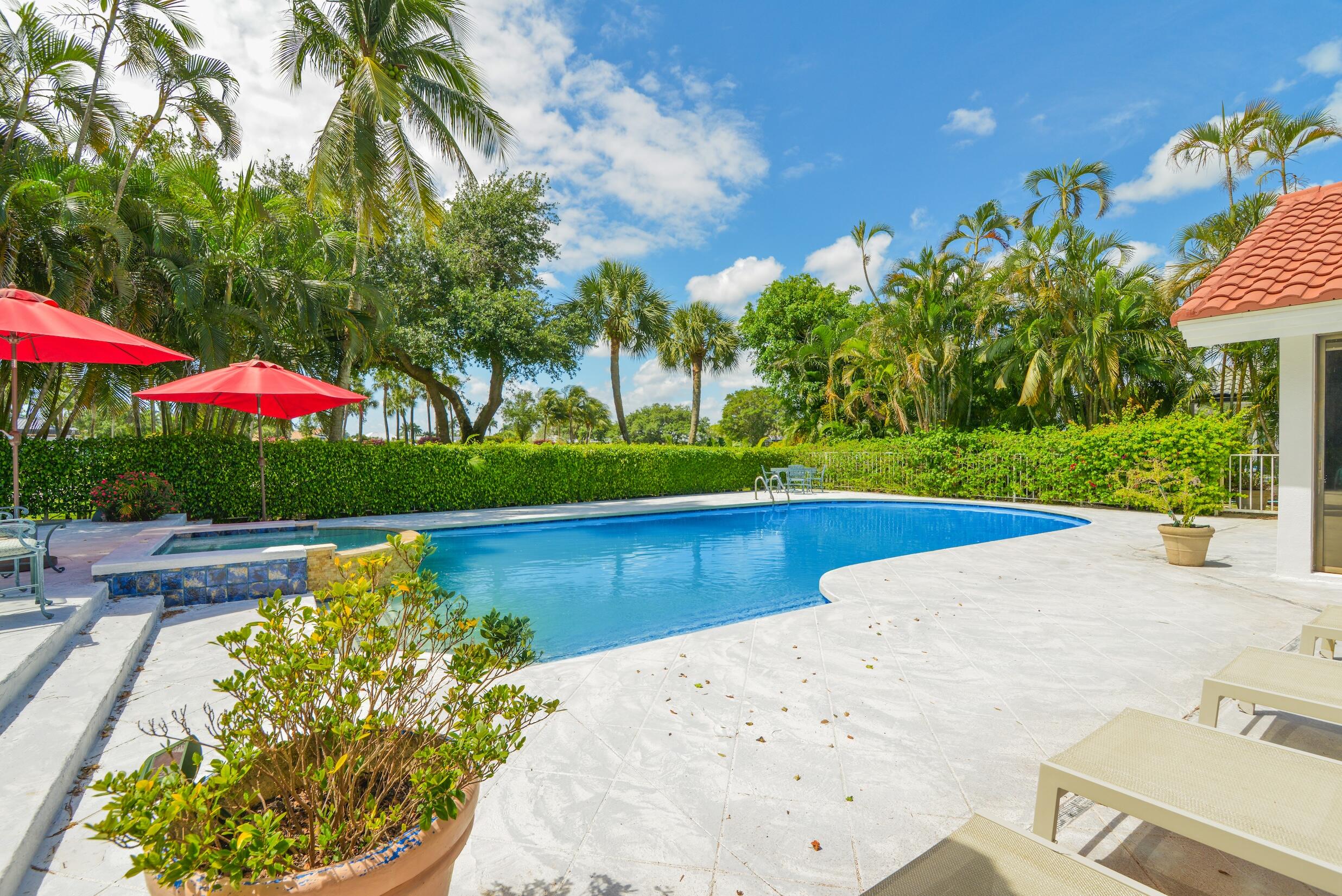 4335 Bocaire Boulevard Boca Raton, FL 33487 - Photo 23 of 55 a view of a swimming pool with a garden and trees