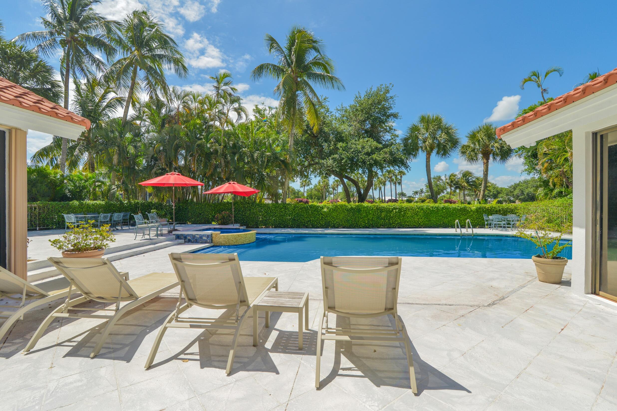 4335 Bocaire Boulevard Boca Raton, FL 33487 - Photo 3 of 55 a view of a swimming pool with a table and chairs under an umbrella