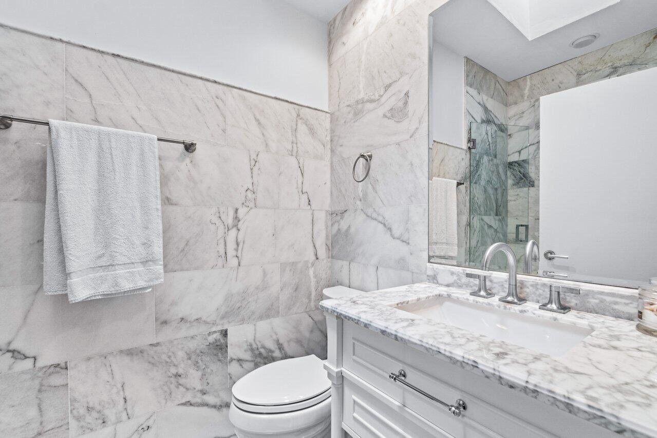 4335 Bocaire Boulevard Boca Raton, FL 33487 - Photo 37 of 55 a bathroom with a granite countertop sink a toilet and shower