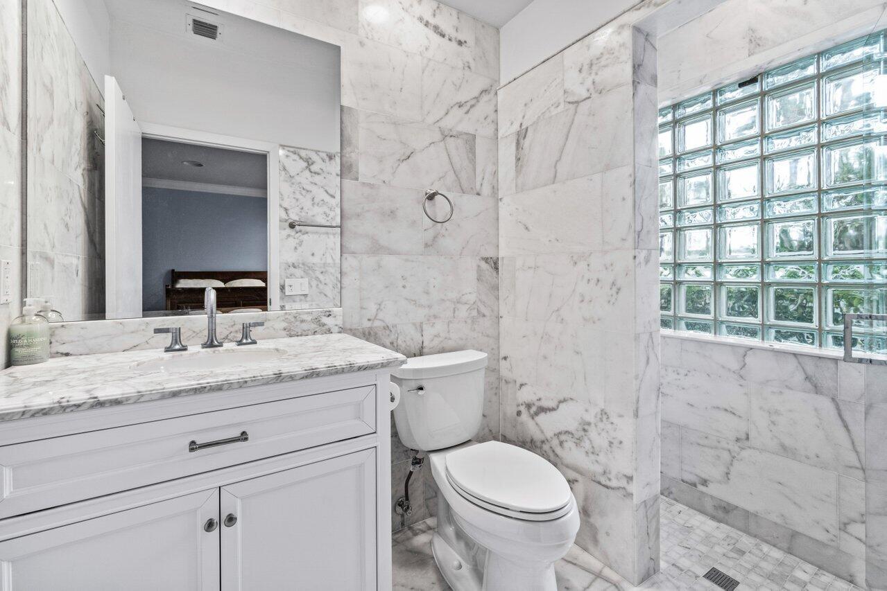 4335 Bocaire Boulevard Boca Raton, FL 33487 - Photo 40 of 55 a bathroom with a granite countertop sink a toilet and a shower