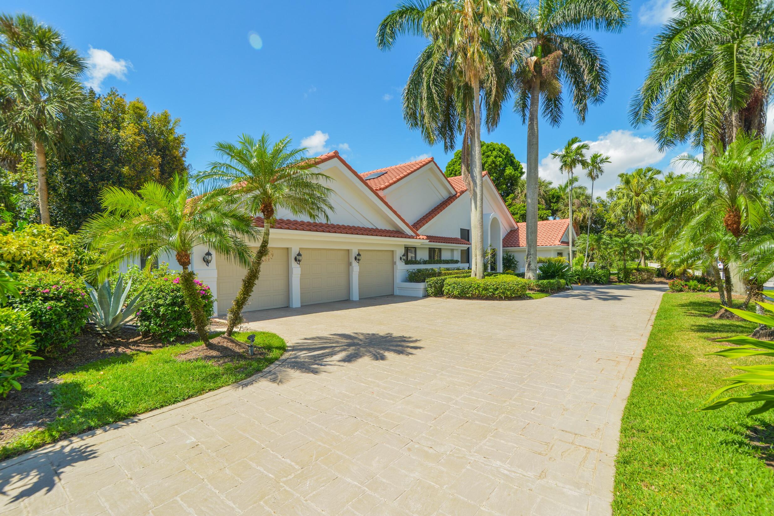 4335 Bocaire Boulevard Boca Raton, FL 33487 - Photo 45 of 55 a front view of a house with a yard and garage