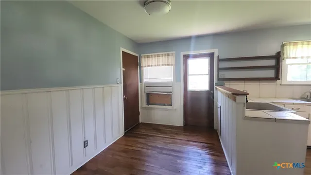 a view of a kitchen in an empty room with a window