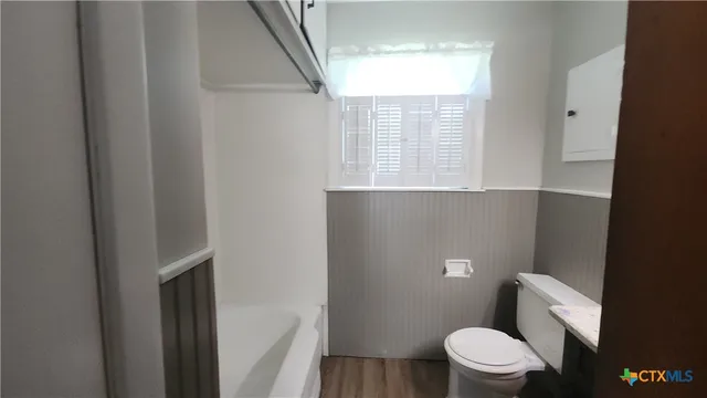 a white toilet sitting next to a window