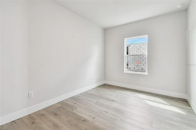 a view of a big room with wooden floor and kitchen