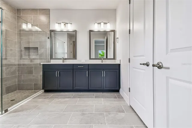 a bathroom with a shower sink and mirror