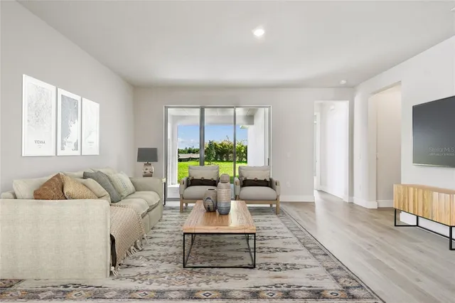 a view of an empty room with window and wooden floor