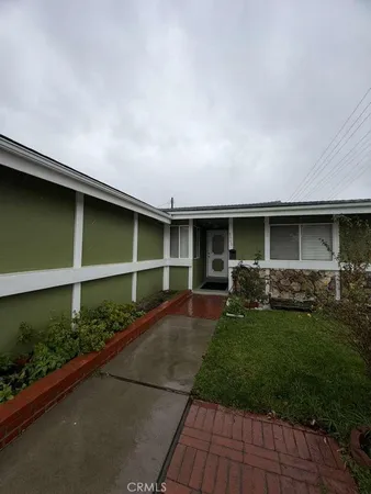a front view of a house with a garden and pathway