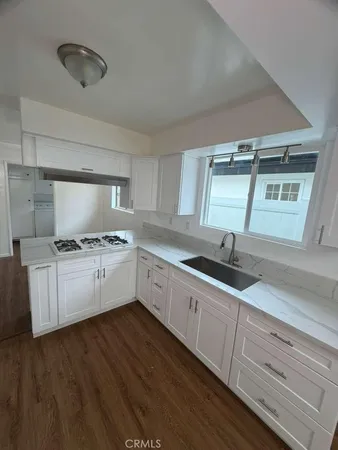 a kitchen with granite countertop white cabinets and white appliances