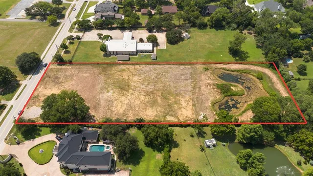 an aerial view of residential houses with outdoor space and trees
