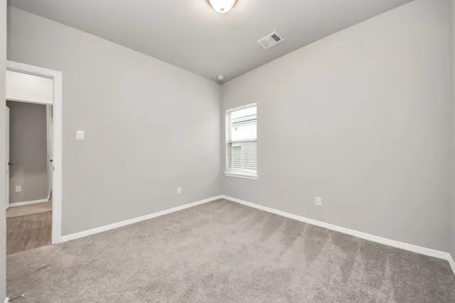 an empty room with windows and closet