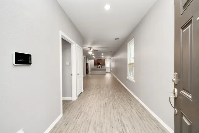 a view of a hallway with wooden floor