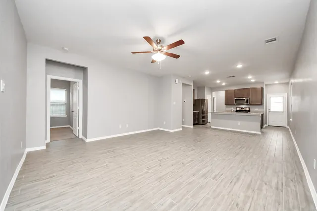 a view of an empty room and kitchen view