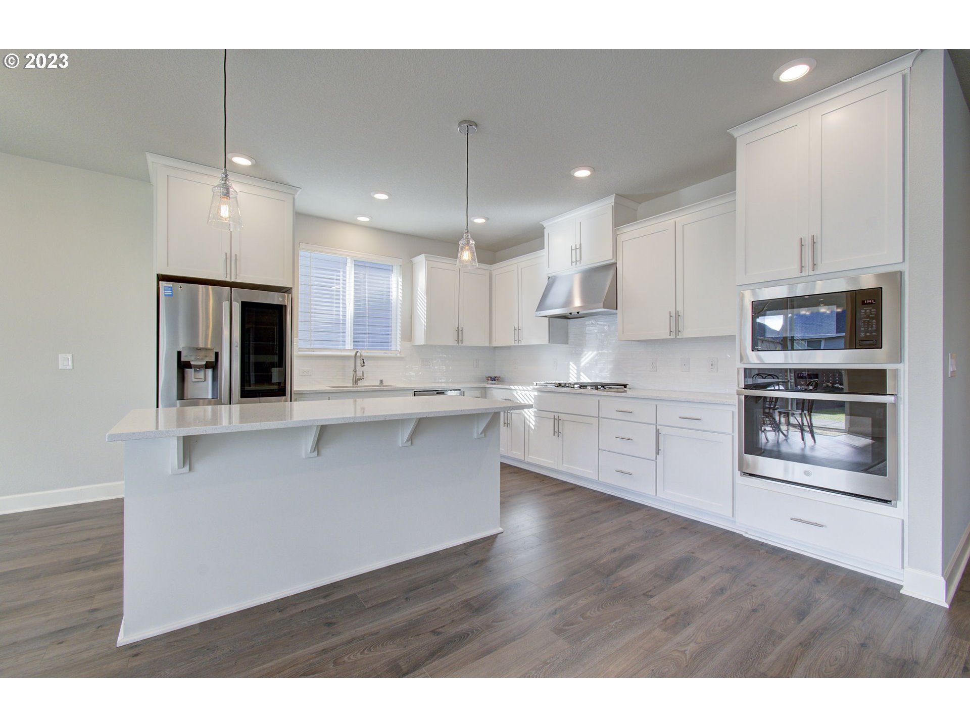 4823 South 16th Drive Ridgefield, WA 98642 - Photo 4 of 37 a open kitchen with kitchen island white cabinets and stainless steel appliances