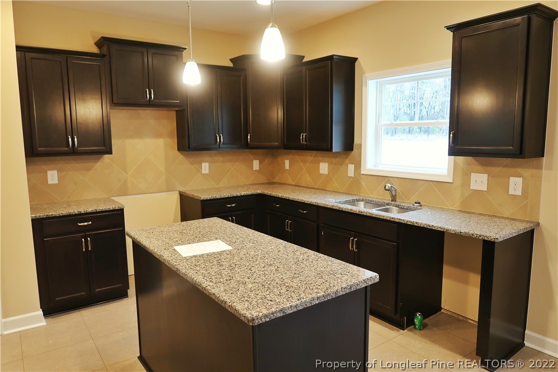 903 Montrose Road Raeford, NC 28376 - Photo 6 of 17 a kitchen with a sink a counter space and cabinets