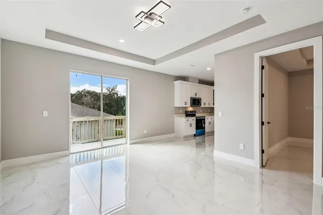 a open kitchen with granite countertop a sink and white cabinets