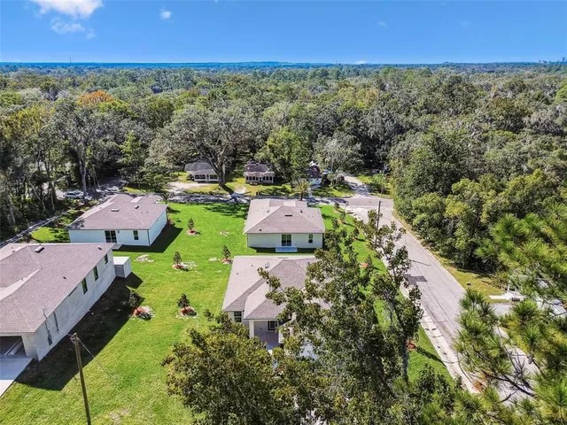 a aerial view of a house with swimming pool and a yard