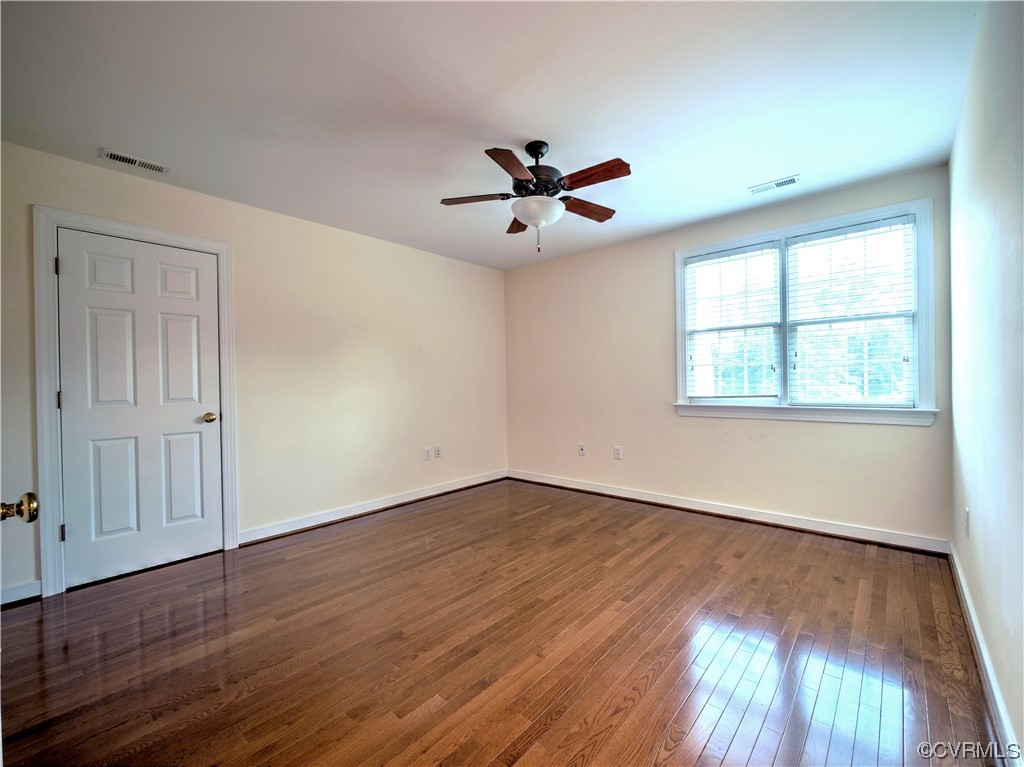 1024 Kingham Drive Midlothian, VA 23114 - Photo 28 of 41 an empty room with wooden floor ceiling fan and windows