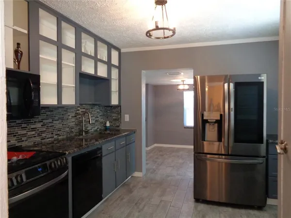 a kitchen with stainless steel appliances granite countertop a stove microwave and sink