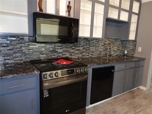 a kitchen with stainless steel appliances granite countertop a stove and a granite counter tops