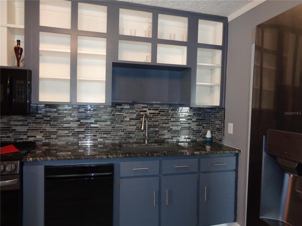 88 Yale Avenue Frostproof, FL 33843 - Photo 19 of 39 a kitchen with stainless steel appliances granite countertop a sink and a granite counter tops