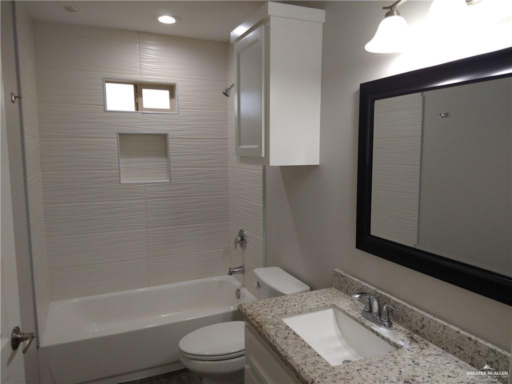 2210 Taxco Court, Unit 2 Edinburg, TX 78542 - Photo 6 of 7 a bathroom with a granite countertop sink toilet and shower