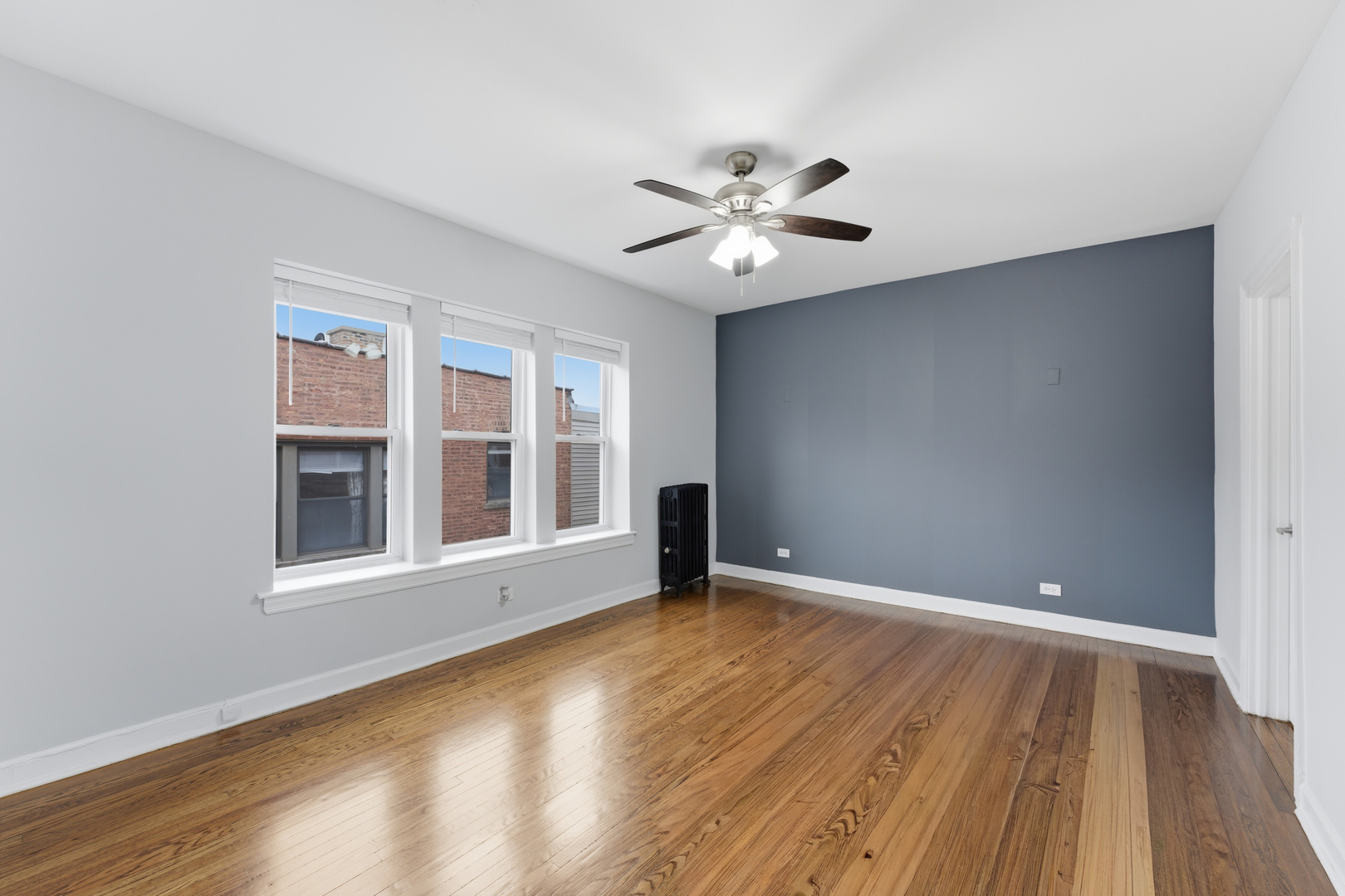 1722 West Juneway Terrace, Unit 3B Chicago, IL 60626 - Photo 2 of 10 a view of an empty room with wooden floor and a window