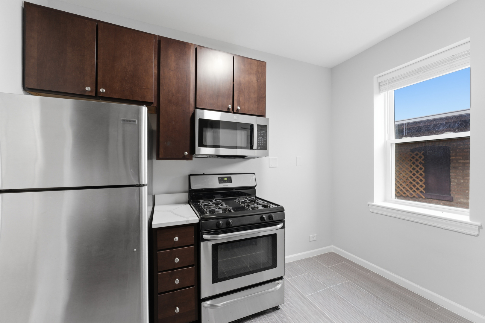 1722 West Juneway Terrace, Unit 3B Chicago, IL 60626 - Photo 5 of 10 a kitchen with cabinets and stainless steel appliances