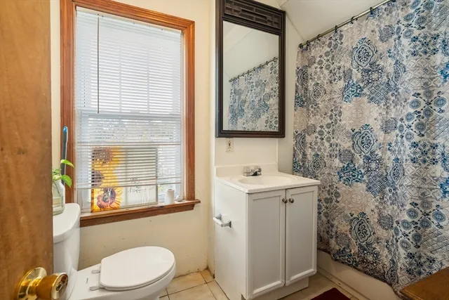 a bathroom with a sink toilet and window