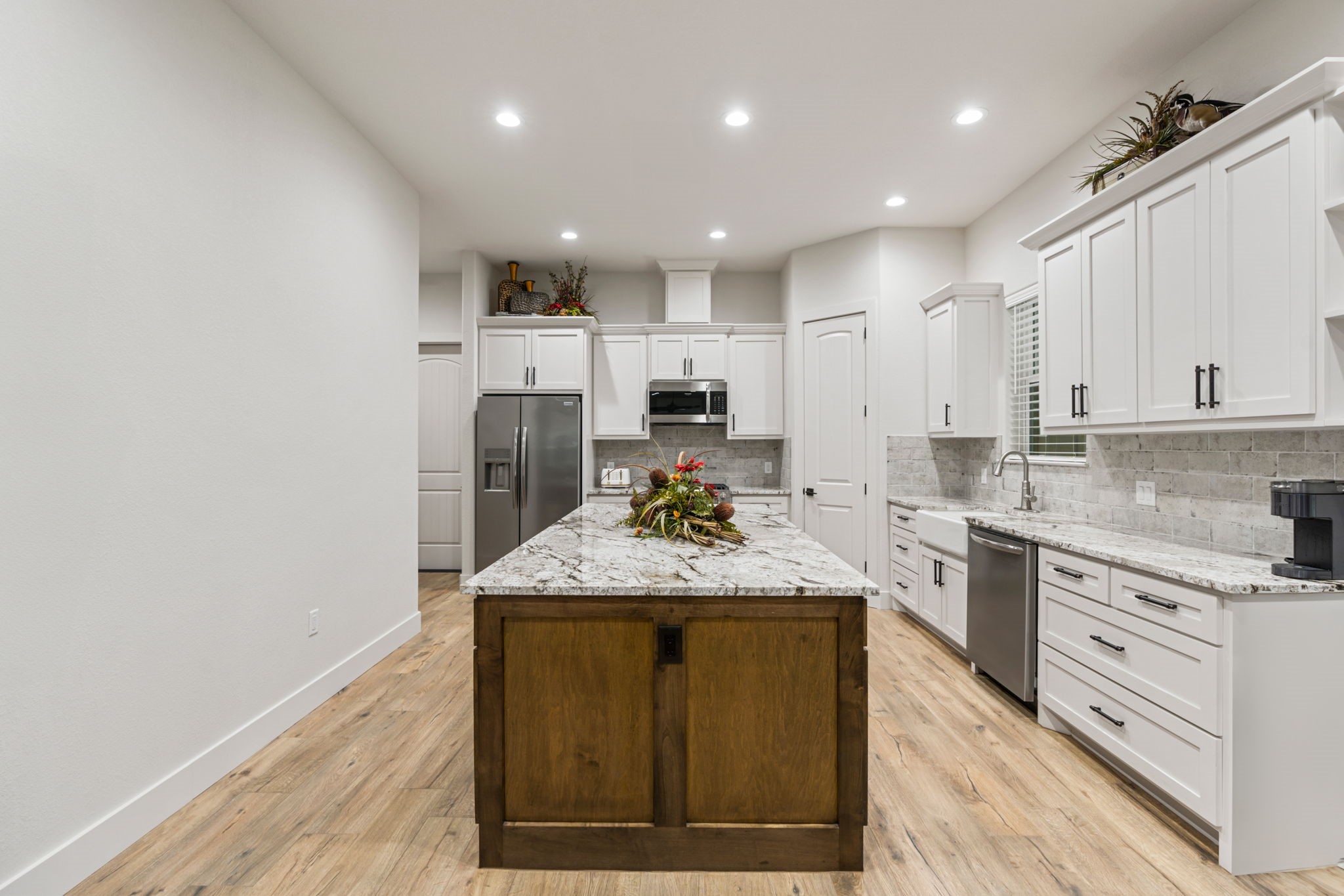 6970 Longmire Road Conroe, TX 77304 - Photo 20 of 48 a kitchen with kitchen island granite countertop wooden cabinets and a refrigerator
