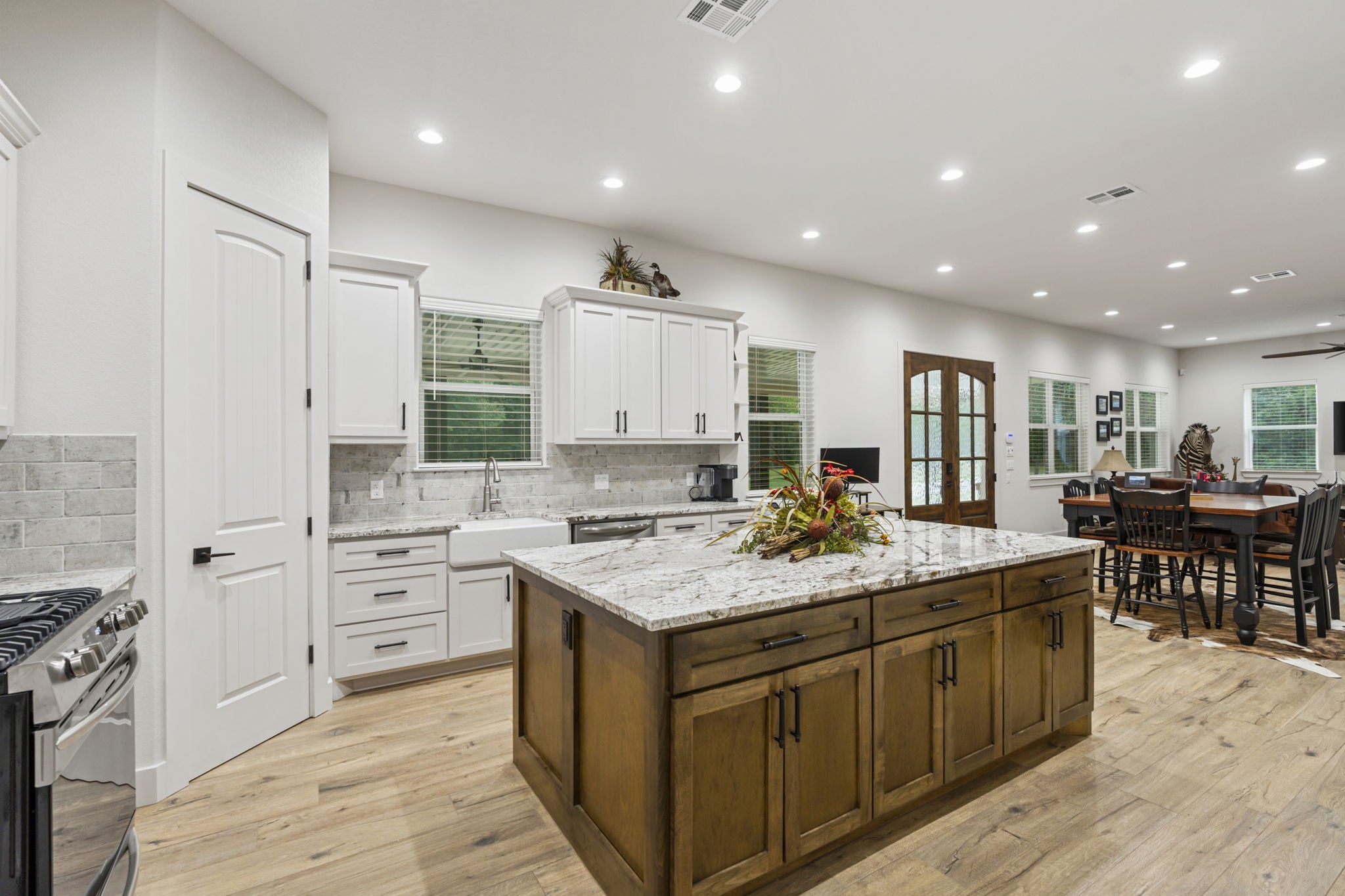 6970 Longmire Road Conroe, TX 77304 - Photo 21 of 48 a room with kitchen island a sink stove and view living room