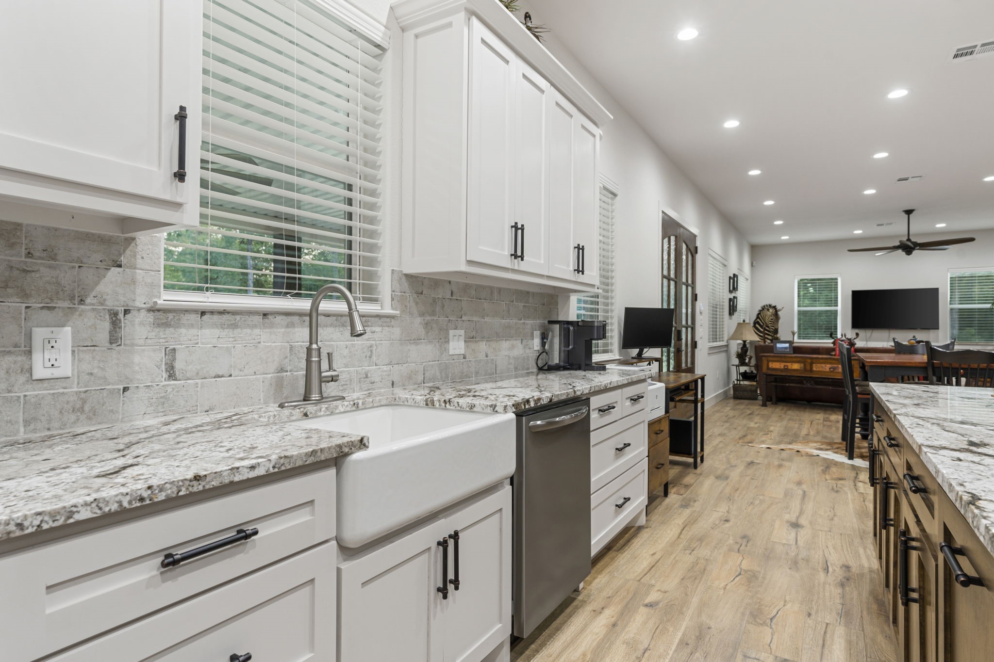 6970 Longmire Road Conroe, TX 77304 - Photo 22 of 48 a kitchen with stainless steel appliances granite countertop sink stove microwave and cabinets