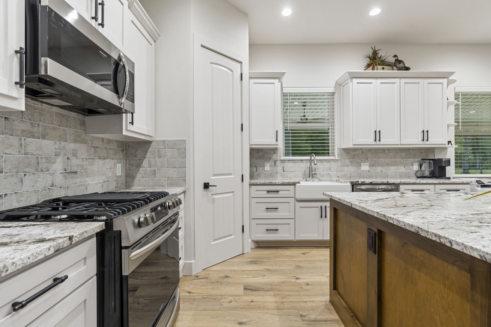 6970 Longmire Road Conroe, TX 77304 - Photo 24 of 48 a kitchen with stainless steel appliances white cabinets and stove