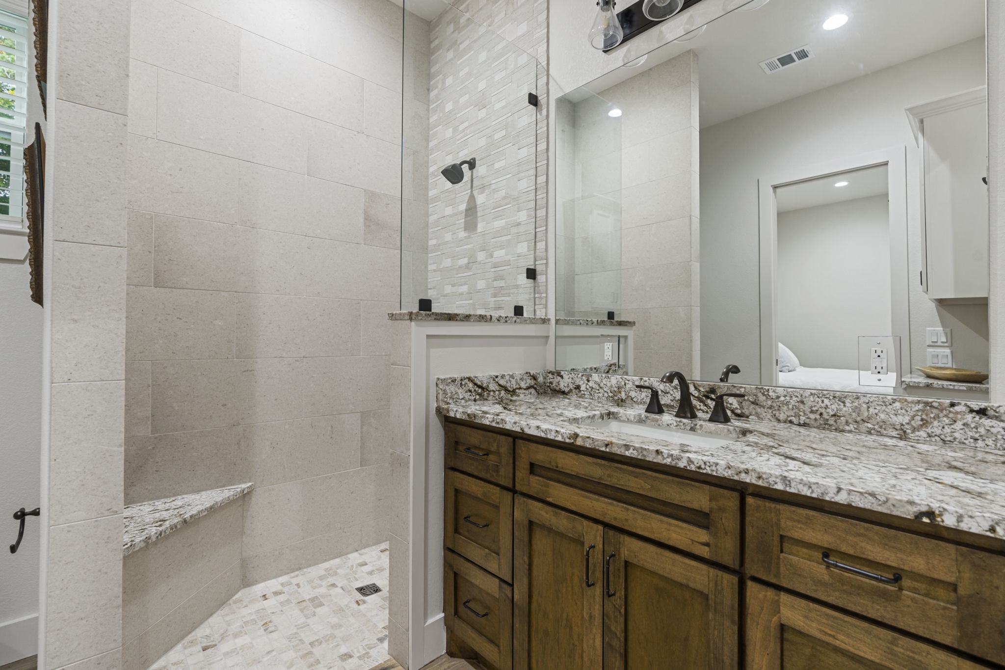 6970 Longmire Road Conroe, TX 77304 - Photo 28 of 48 a bathroom with a granite countertop sink and a mirror