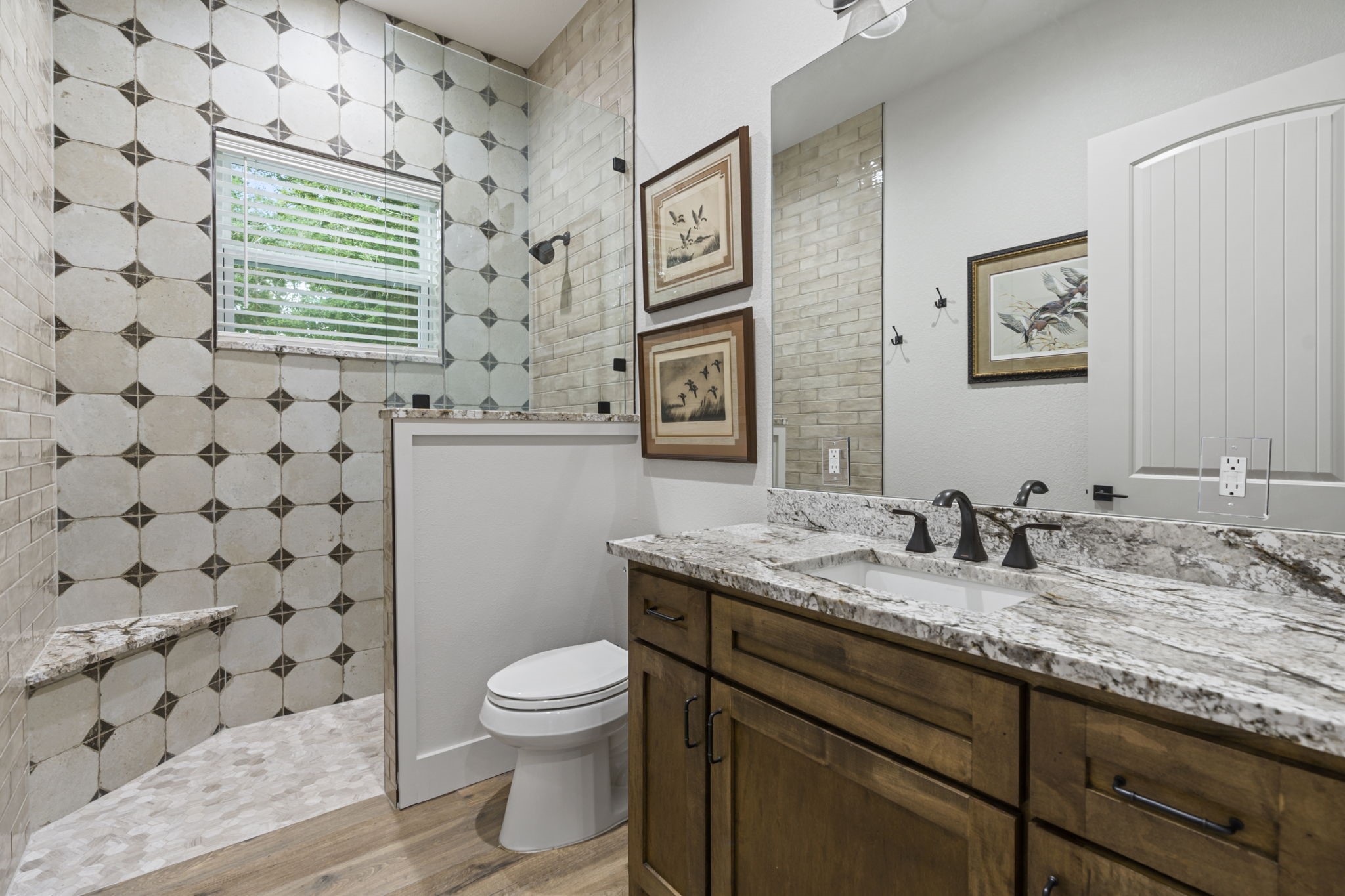 6970 Longmire Road Conroe, TX 77304 - Photo 32 of 48 a bathroom with a granite countertop toilet sink and mirror