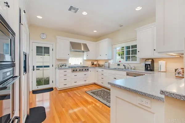 a kitchen with stainless steel appliances granite countertop a refrigerator and a stove top oven
