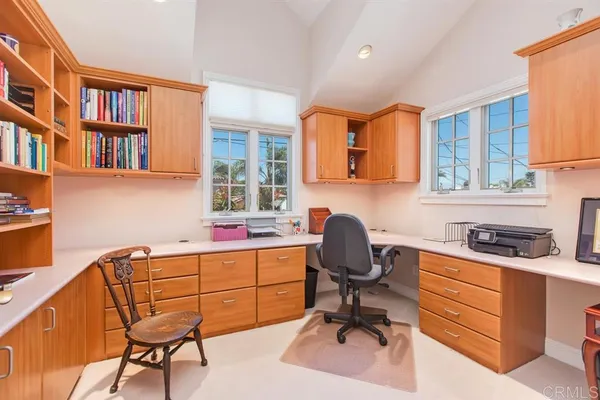 a view of a workspace with furniture and a window