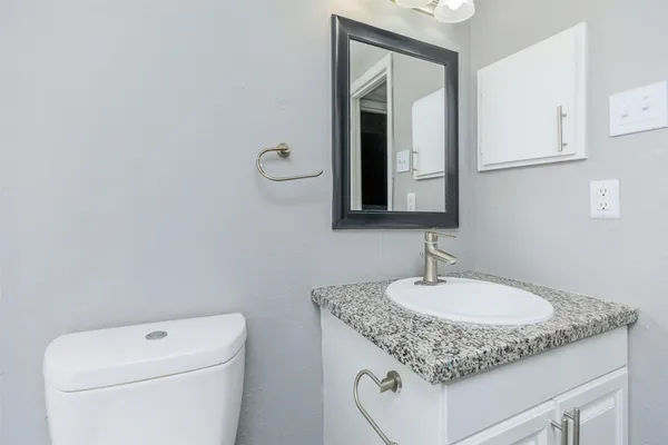 a bathroom with a granite countertop sink a toilet and a bathtub