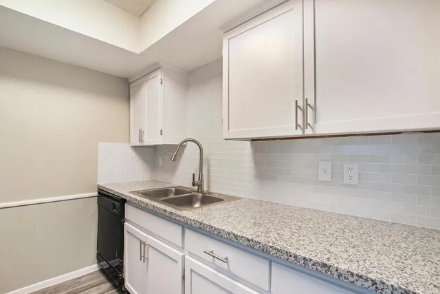 a kitchen with granite countertop a sink stainless steel appliances and cabinets