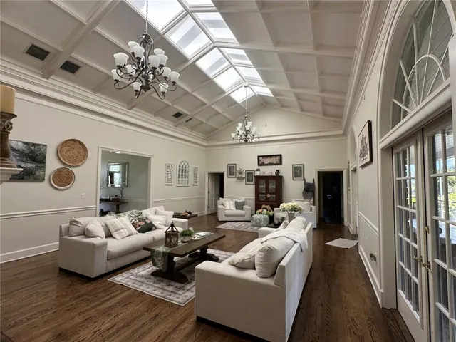 a dining room with furniture a chandelier and wooden floor