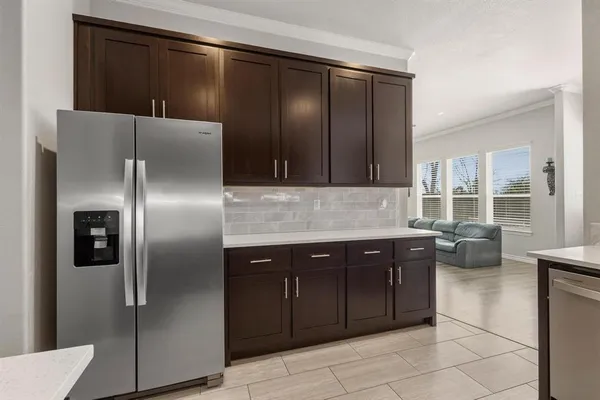 a kitchen with stainless steel appliances kitchen island granite countertop a table chairs sink and cabinets