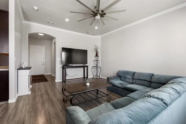 a living room with furniture kitchen view and a flat screen tv