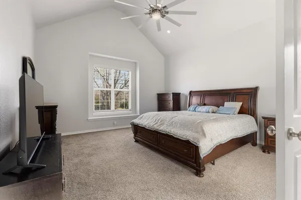 a spacious bedroom with a bed and a chandelier