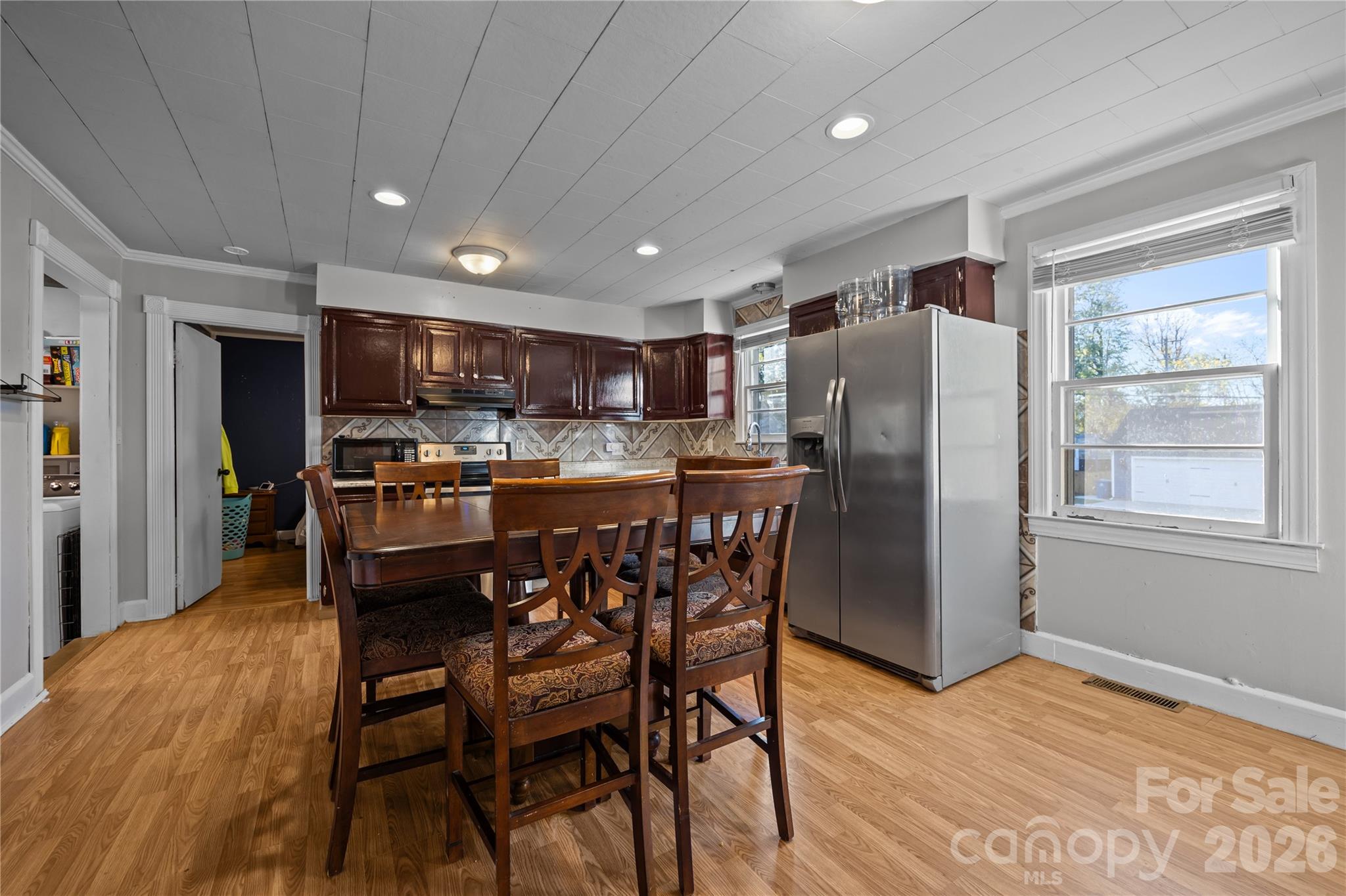 145 Duke Street Cooleemee, NC 27014 - Photo 14 of 27 a kitchen with stainless steel appliances a dining table chairs refrigerator and microwave