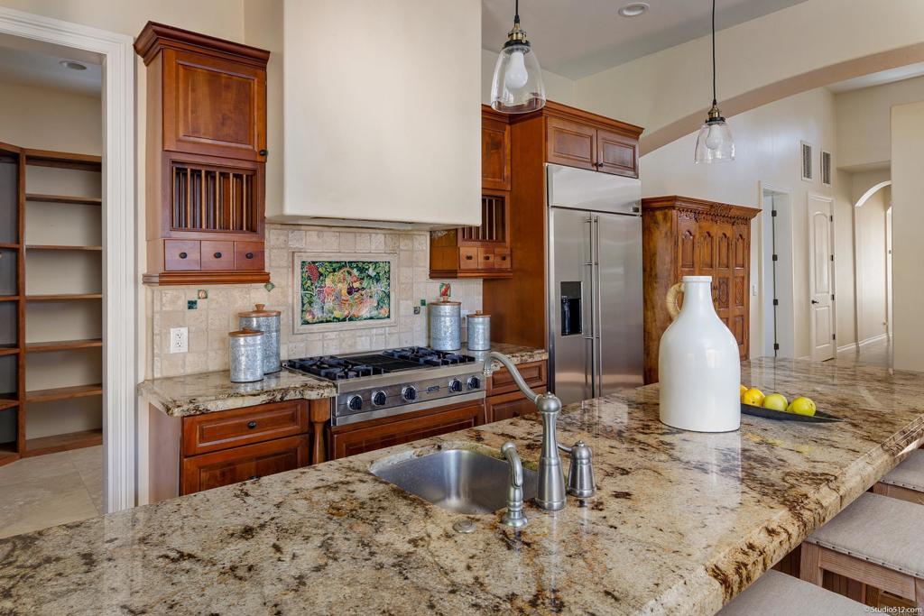 1455 Independence Way Vista, CA 92084 - Photo 12 of 31 a kitchen with stainless steel appliances granite countertop a stove a sink and a wooden cabinets