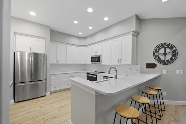 a kitchen with stainless steel appliances a stove sink and refrigerator