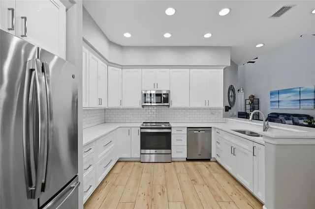 a kitchen with a sink cabinets and wooden floor