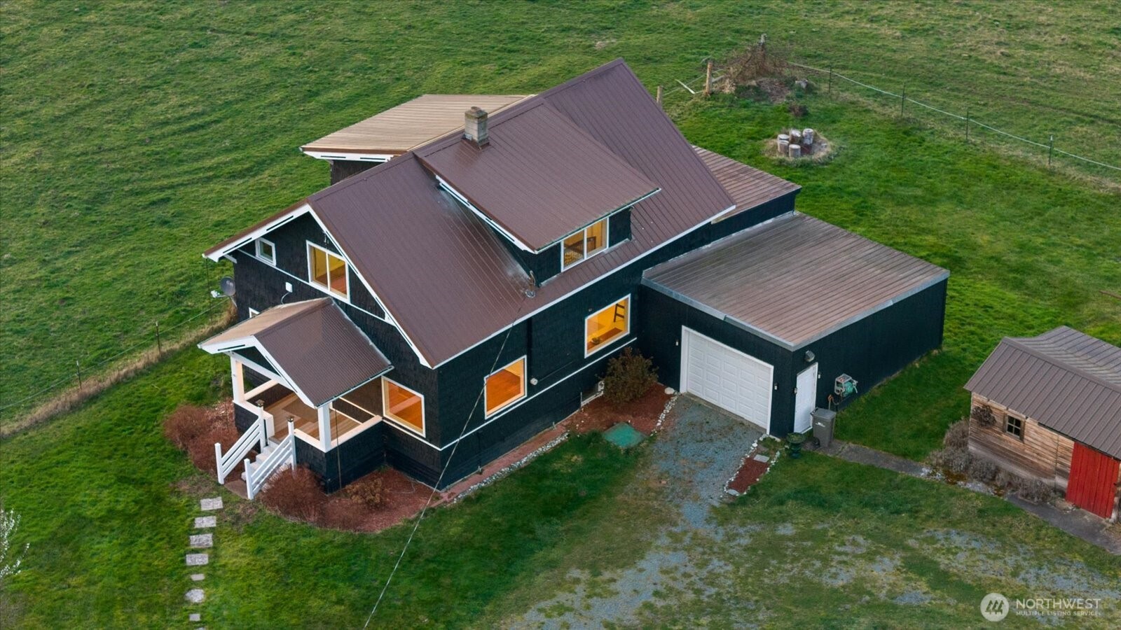 an aerial view of residential house with outdoor space and trees all around