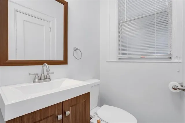 a bathroom with a sink a toilet and mirror