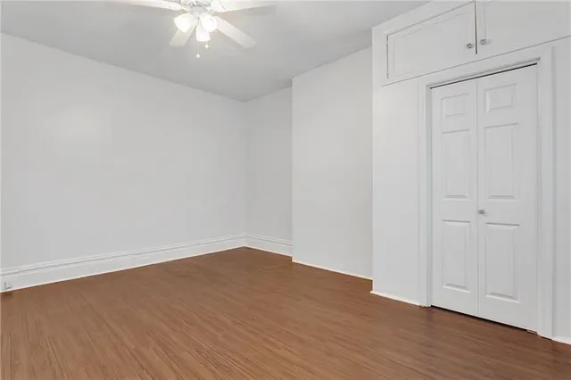 a view of an empty room with wooden floor
