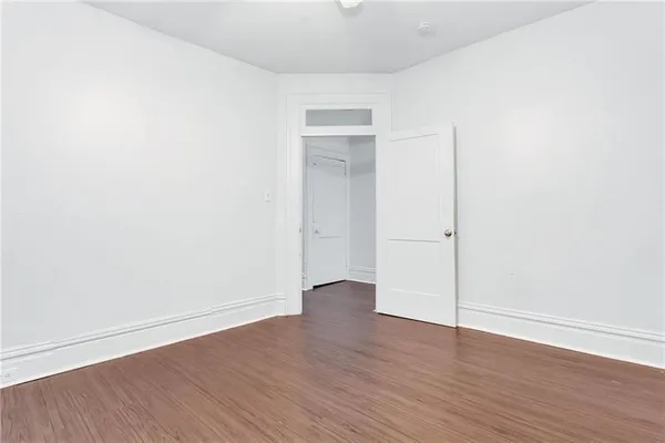 an empty room with wooden floor and closet
